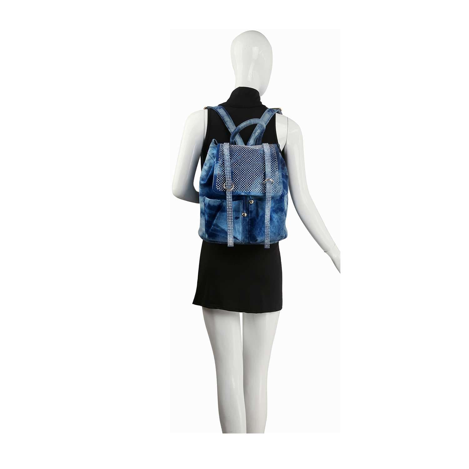 A mannequin wears a sleeveless black dress and the Rhinestone Accent Fashion Backpack, shown from the back. The backpack’s flap and studded design give the outfit a casual yet stylish vibe.