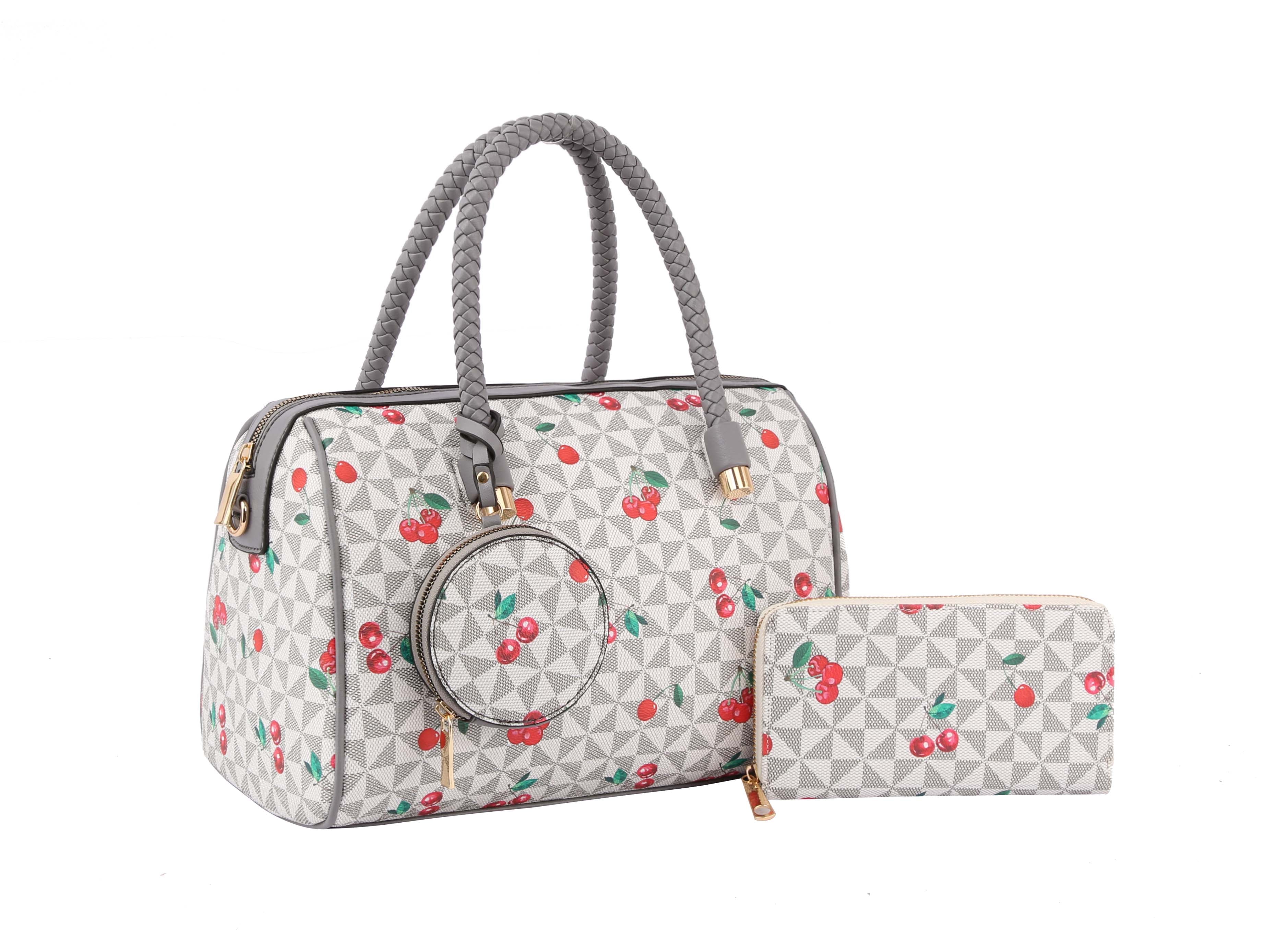 The Signature Cherry Print Satchel Set features a faux leather handbag and matching wallet with a geometric pattern, red cherry designs, gold zipper accents, and a detachable strap, displayed on a white background.