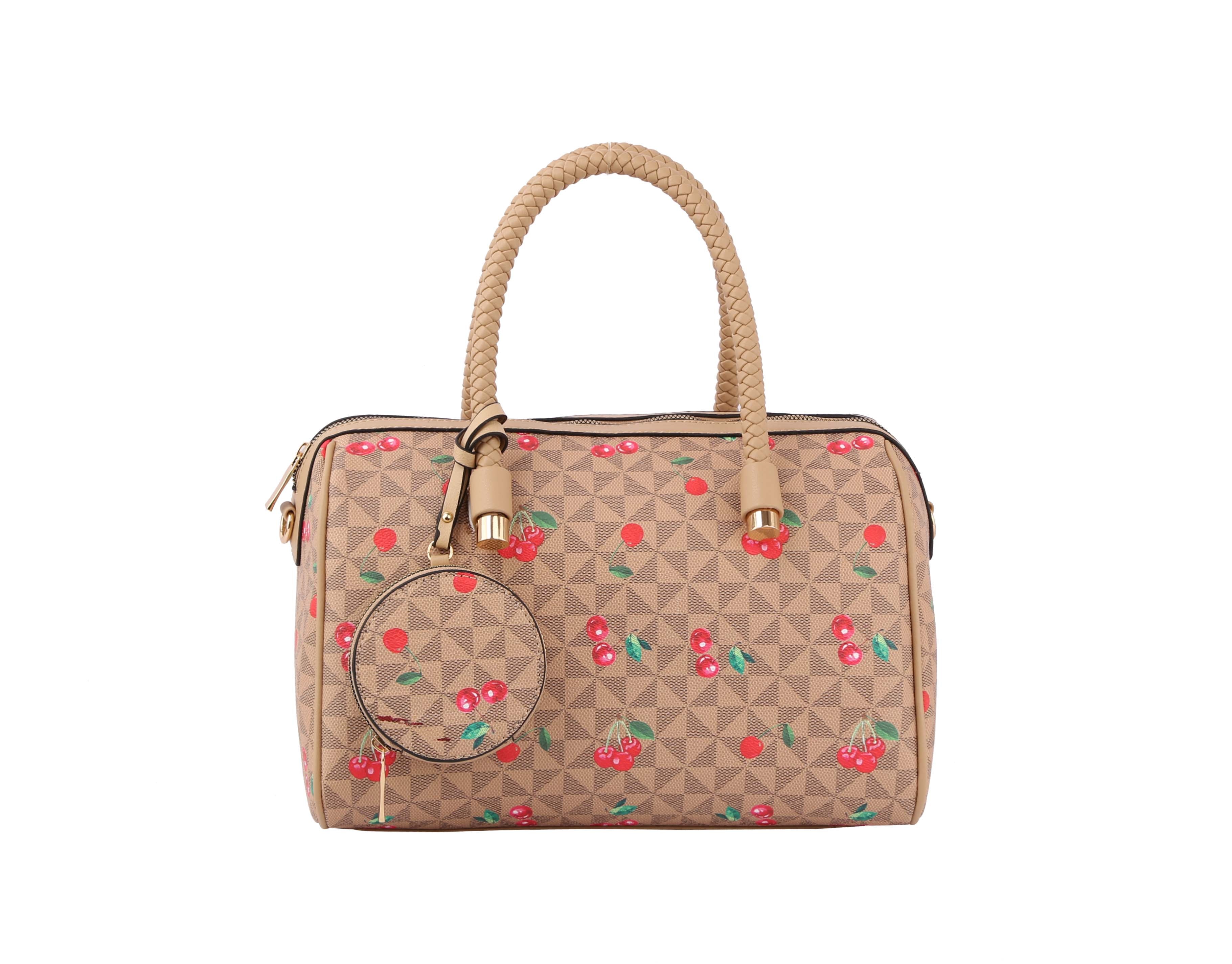 The Signature Cherry Print Satchel Set features a tan faux leather handbag with braided handles, gold hardware, red cherry and green leaf print, detachable strap, and a matching round coin pouch attached to one handle.