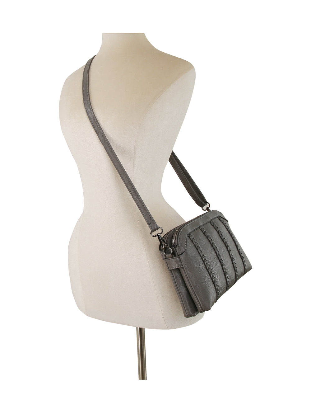 The Braid Accented Dual Opening Crossbody, featuring gray quilted faux leather, gunmetal hardware, and a long adjustable strap, is displayed on a beige dress form mannequin from the back and side views.