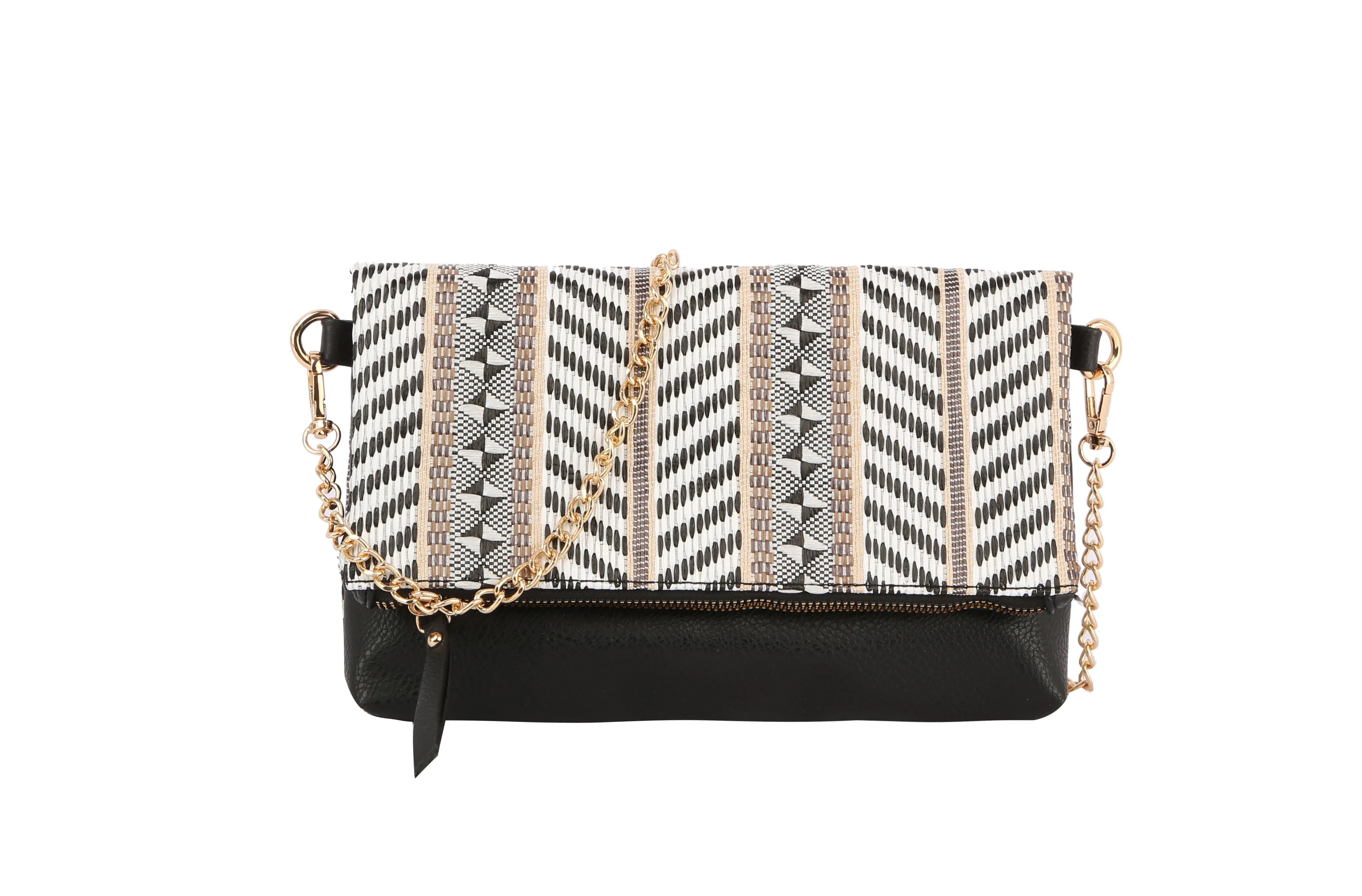 The Colorful Woven Crossbody Bag features a black faux leather base, a white, black, and gold geometric flap, gold-tone hardware, chain strap accents, and a stylish black tassel.