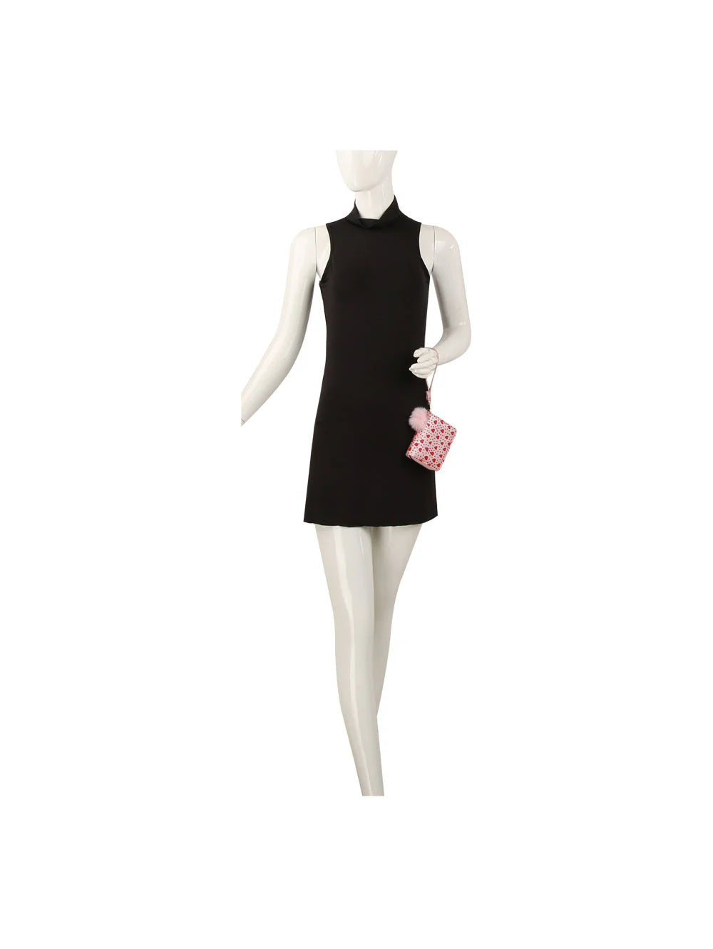 A mannequin wears a sleeveless black mini dress and holds the Dainty Heart Print Petite Wristlet Wallet, a small pink faux leather handbag with red heart patterns.
