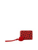 The Dainty Heart Print Petite Wristlet Wallet is a red faux leather wallet with black heart prints, card slots inside, a matching wristlet strap, and a fluffy red pom-pom. It’s displayed centered on a white background.
