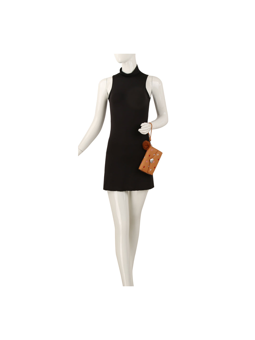 A mannequin wears a sleeveless black mini dress and holds a Heart Print Tri Fold Wristlet Wallet.