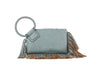 The Fringe Accented Wristlet Clutch Bag features light blue faux leather, a large braided circular handle, gold-toned hardware, tan fringe detailing on the bottom and sides, and a matching tassel on the handle.