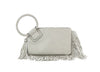 The Fringe Accented Wristlet Clutch Bag is a light gray faux leather handbag featuring a large braided circular handle, zip closure, gold-toned hardware, and decorative fringe along the right side and bottom edge.