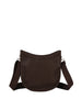 The Saddle Bag Inspired Curved Crossbody is a dark brown, crescent-shaped faux leather bag with a wide adjustable strap and smooth minimal design, featuring a top zip closure. Displayed against a plain white background.