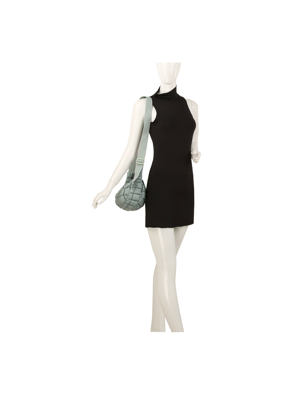 A mannequin in a sleeveless black mini dress carries the Quilted Puffer Crossbody Hobo, a light blue woven nylon bag with an adjustable single strap. The pose is casual against a plain white background.