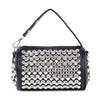 The Studded Rhinestone Barrel Bag is a black faux leather handbag with a short strap, adorned with large round silver studs and rhinestones on the front and sides. It features a rectangular shape and metallic hardware accents.