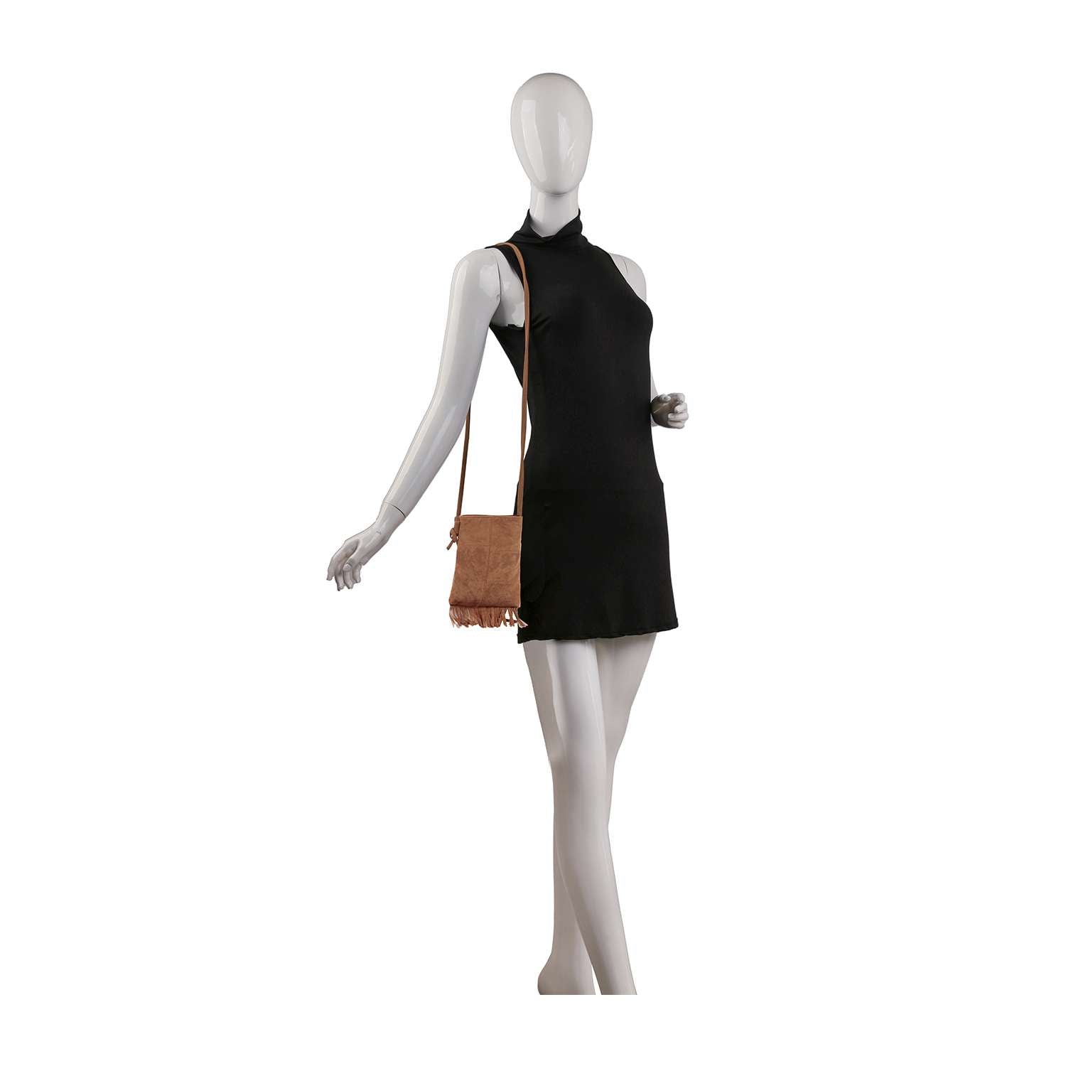 A faceless mannequin wears a sleeveless black mini dress and carries the Sueded Fringe Crossbody Sling, posed with one arm bent and the other extended.