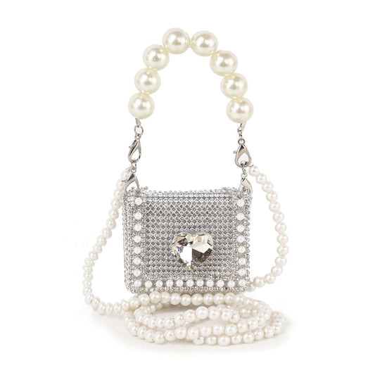 The Pearl And Rhinestone Accented Ultra Petite Evening Bag features silver faux leather, rhinestone accents, a heart-shaped gem, pearl beaded handle, and extra strap—perfect for adding sparkling glamour to any outfit.