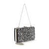 The Dazzling Cluster Stone Accented Evening Bag is a black frame clutch purse with silver sequins, a detachable silver chain strap, metal clasp, and faux leather material, shown on a white background.