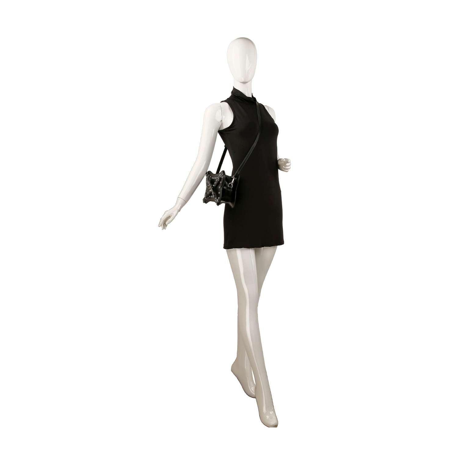 A mannequin wearing a sleeveless black mini dress and a sleek black Studded Belted Shoulder Bag, posed as if walking, on a white background.