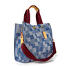 Introducing the Denim Print Contrast Tote Handbag—a stylish blue tote with a checkered pattern, gold hardware, top zip closure, yellow leather accents, red sturdy handles, an adjustable red shoulder strap, and a tag.