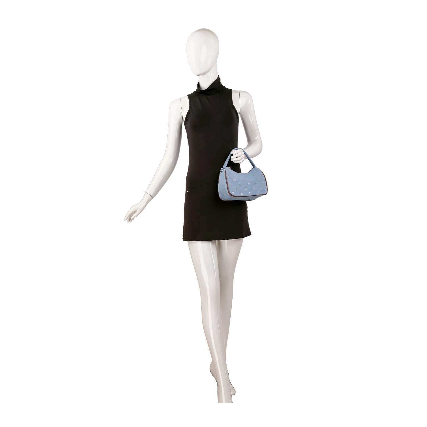 A mannequin in a sleeveless black mini dress holds the Cute Petite Denim Hobo, a small light blue denim handbag with double handles, against a plain white background.