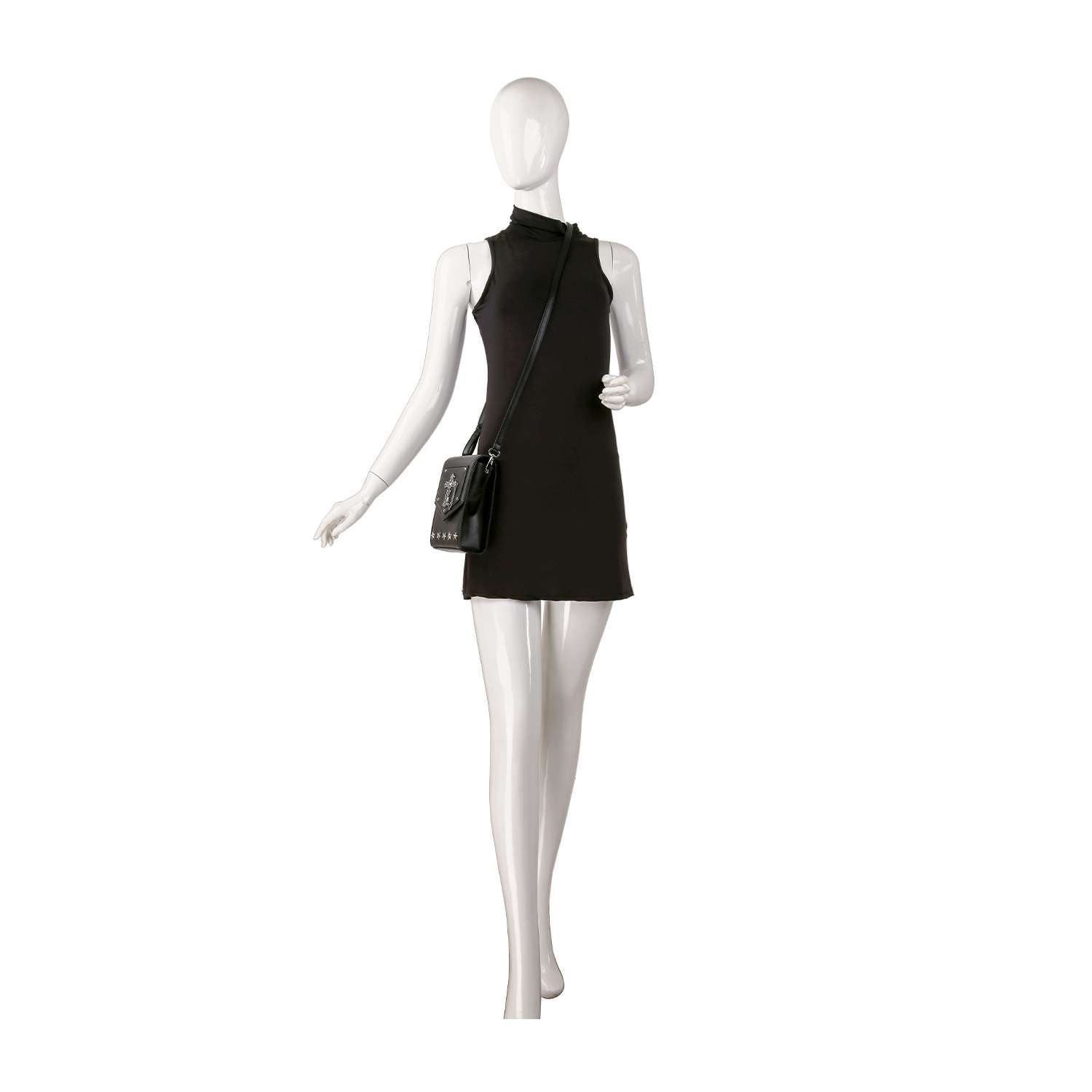 A white mannequin stands against a plain background, wearing a sleeveless black mini dress and carrying the Decorative Cross Accented Petite Crossbody Bag.