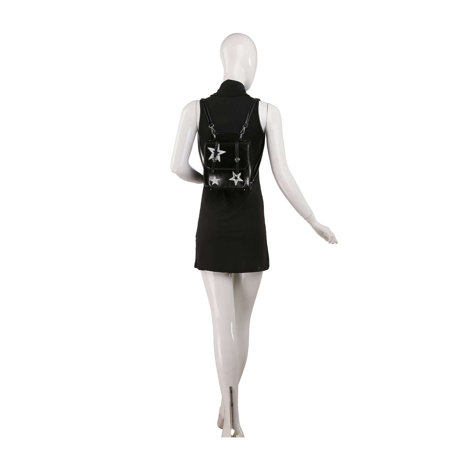 A mannequin in a sleeveless black dress faces away, showcasing the Sparkling Star Design Petite Backpack with silver star accents, set against a plain white background.