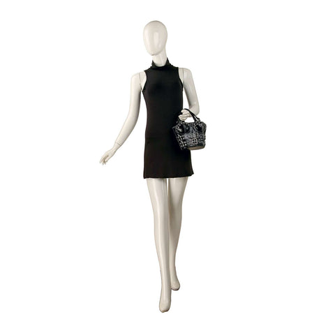 A mannequin holds the Studded Bustier Design Petite Tote while wearing a sleeveless, short black dress, posed against a plain white background.