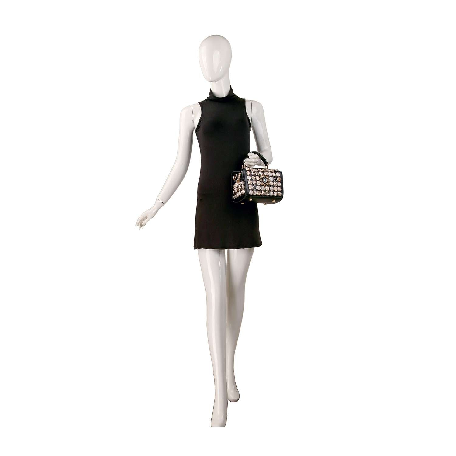 A mannequin in a sleeveless black mini dress holds the Intricate Button Design Satchel Handbag, a small square faux leather bag with gold-toned hardware and a grid of round decorative embellishments on the front.