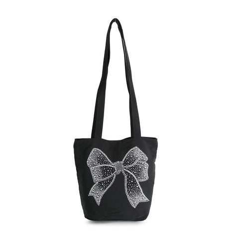 The Rhinestone Bow Design Tote Handbag is a black tote with two long handles, made from sturdy fabric and features a large white, rhinestone-studded bold bow on the front.