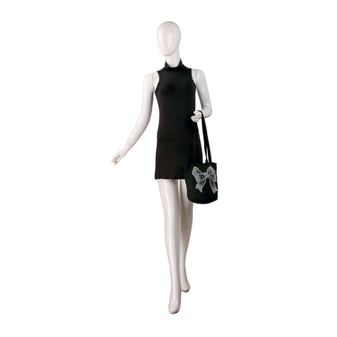 A mannequin in a sleeveless black mini dress holds the Rhinestone Bow Design Tote Handbag, featuring a striking white bow, posed against a plain white background.