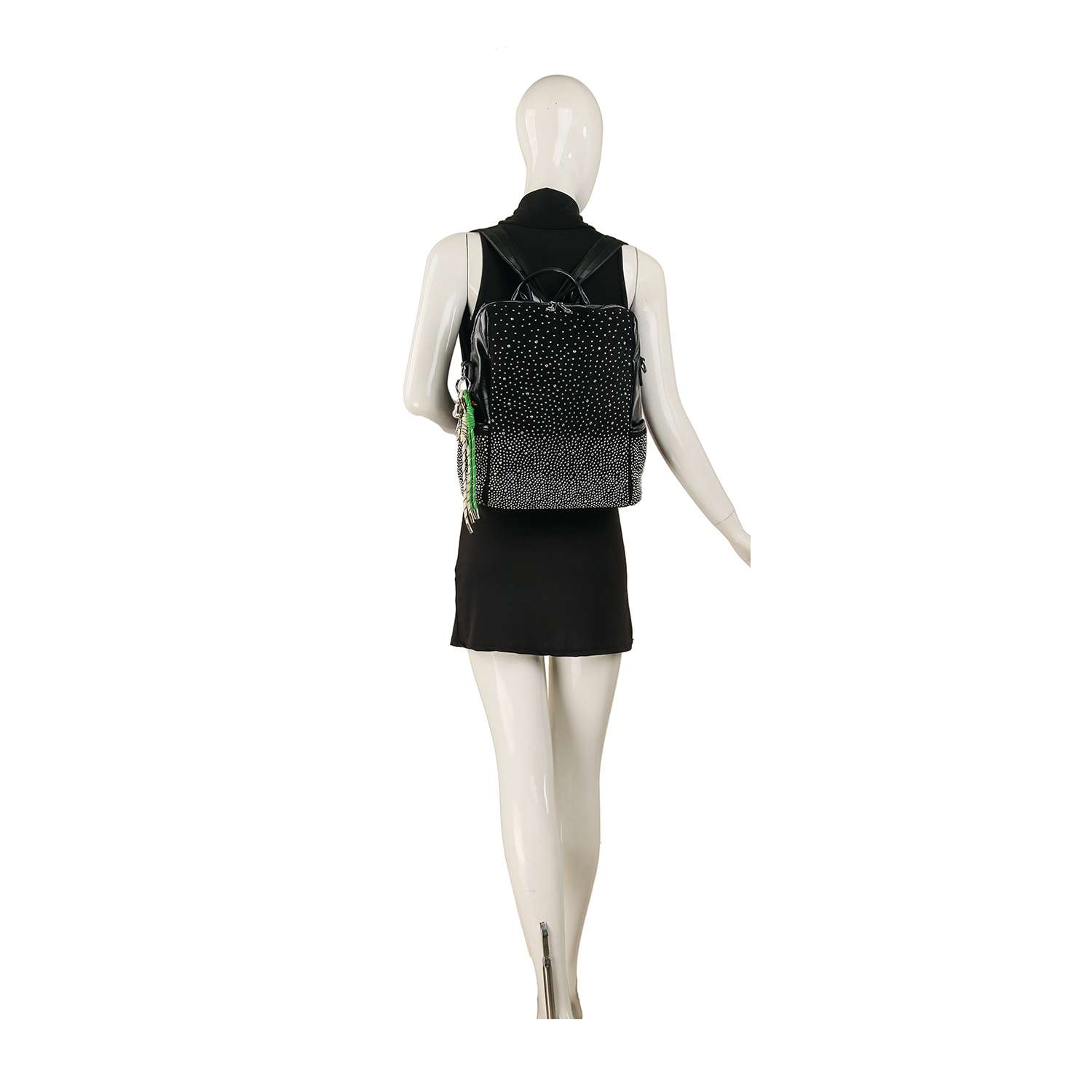A mannequin in a sleeveless black dress showcases the Glamorous Stone Design Fashion Backpack, featuring a chic black and white speckled pattern with a green keychain, displayed from the back against a plain white background.