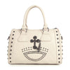The Cross And Stud Accented Petite Satchel Handbag features cream-colored faux leather, double handles, and metal studs arranged in a cross and semicircle on the front, with extra stud accents along the edges.