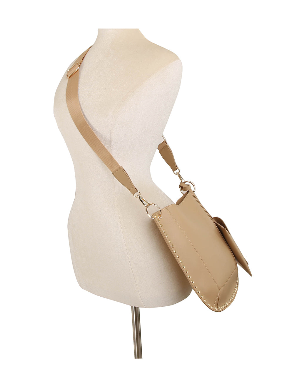 The Studded Slim Crossbody Bag is displayed on a mannequin torso, featuring gold hardware, visible edge stitching, and an adjustable strap. Its minimalist beige design offers modern style against a white background.