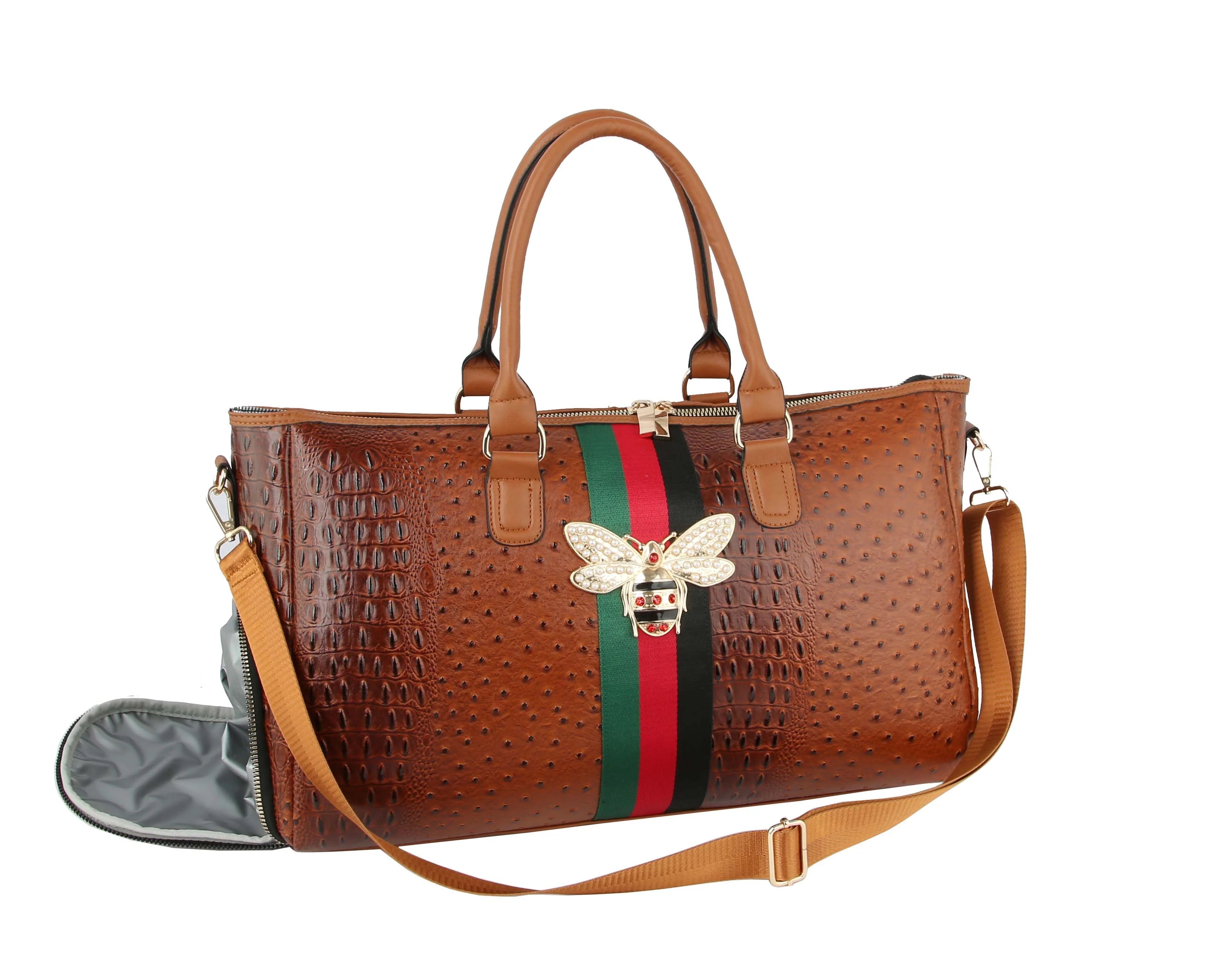 The Croc Embossed Rhinestone Bee Weekender is a brown faux leather handbag with two top handles, a detachable strap, gold-toned hardware, red and green vertical stripe, and a jeweled bee ornament on the front.
