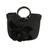 The Raised Flower Tote Handbag is a black faux leather bag with round handles, gold toned hardware, a striking 3D flower and leaf design on the front, and a detachable strap for versatile styling.