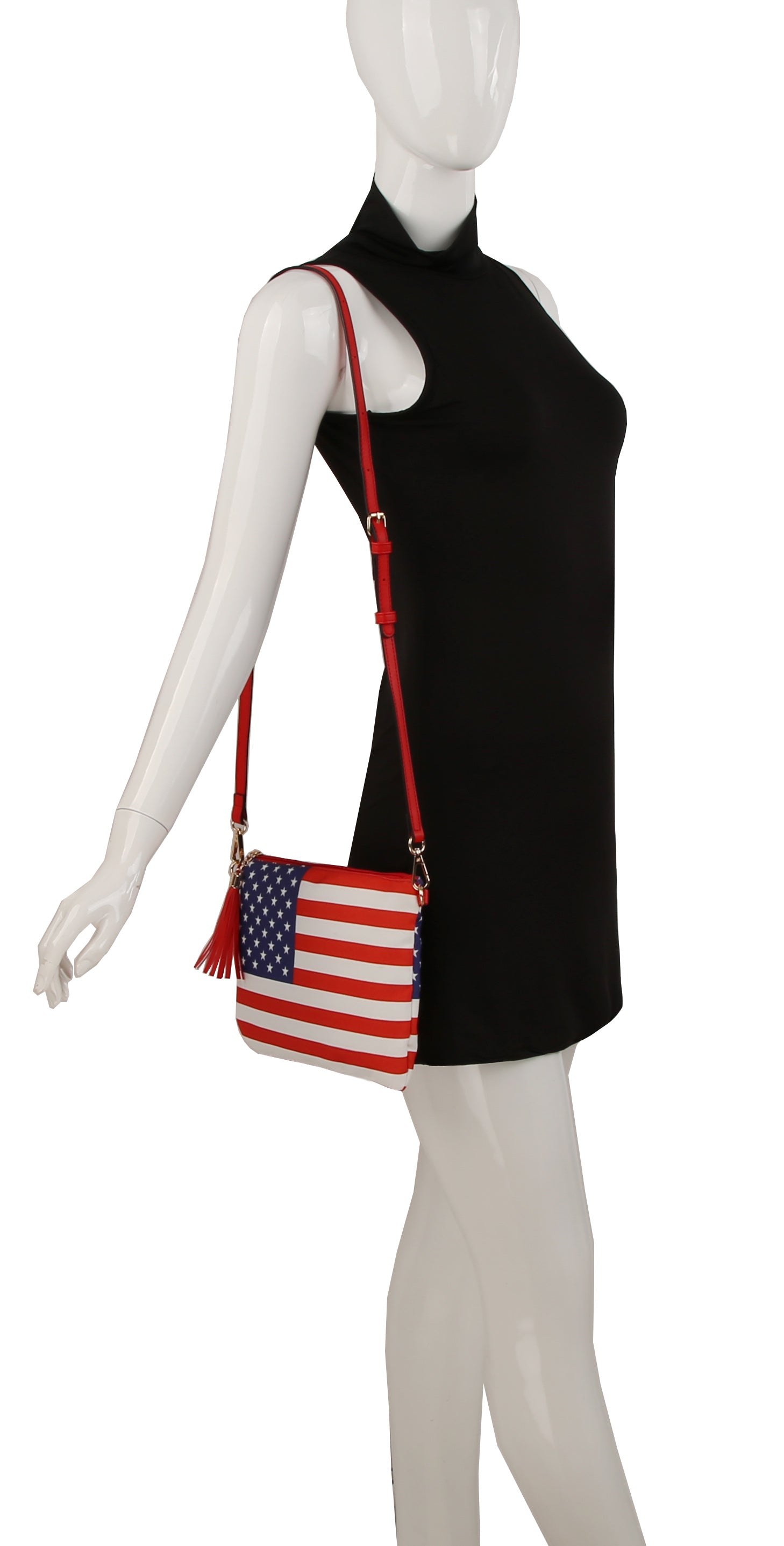A mannequin in a sleeveless black dress showcases the American Flag 3 Piece Crossbody Set, featuring an adjustable strap and red accents, displayed on a white background.