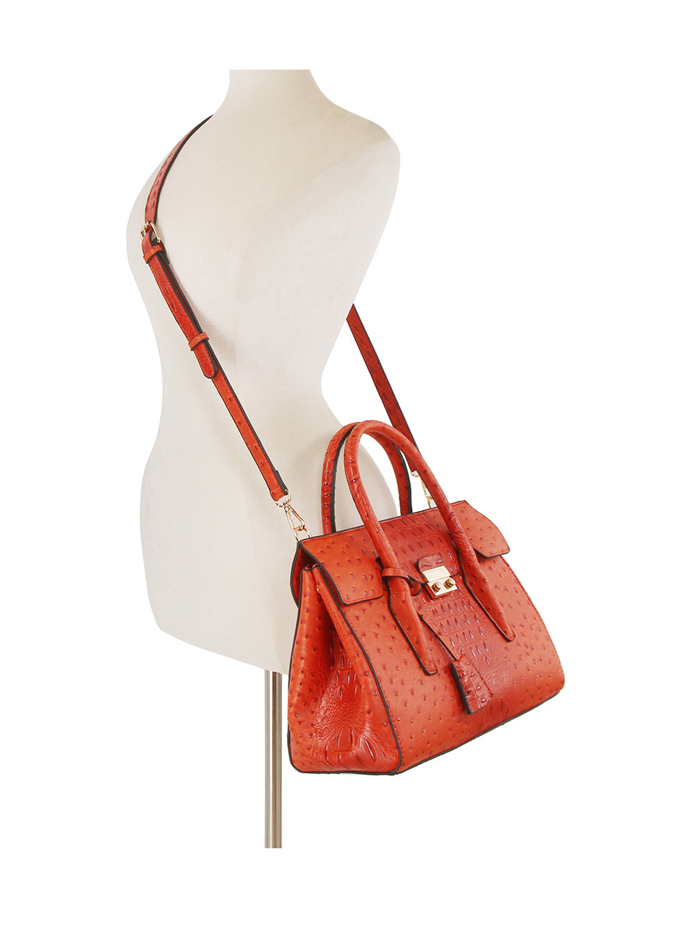 The Embossed Classic Tote Handbag Set in red textured faux leather features top handles, a crossbody strap, front flap, gold toned hardware, embossed pattern, and is tablet compatible. Displayed on a white mannequin torso.