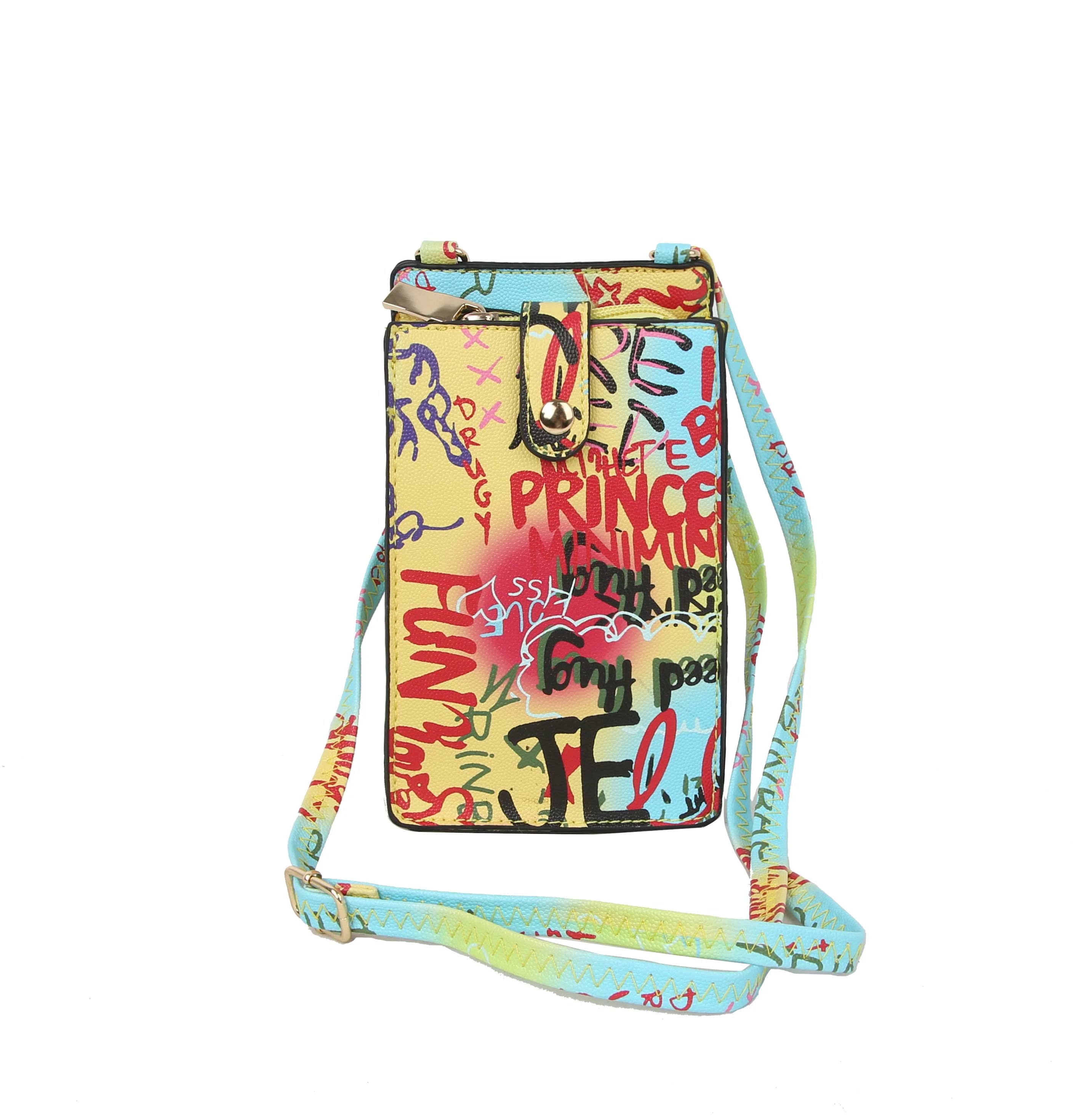 The Urban Graffiti Cell Phone Crossbody Sling is a colorful faux leather bag with graffiti-style text and doodles in red, blue, yellow, and black on a pale background. It has an adjustable strap, gold-tone hardware, and a snap-closure front pocket.