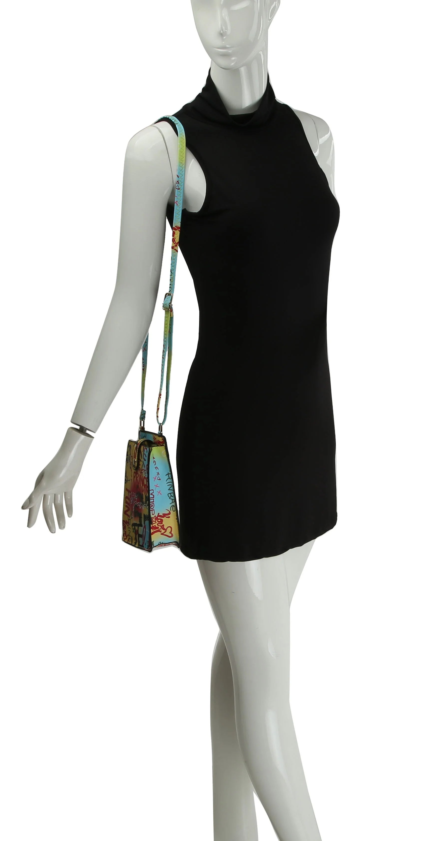 A mannequin wears a sleeveless black mini dress and carries the Urban Graffiti Cell Phone Crossbody Sling, a small colorful bag with adjustable strap and faux leather details, over its shoulder.