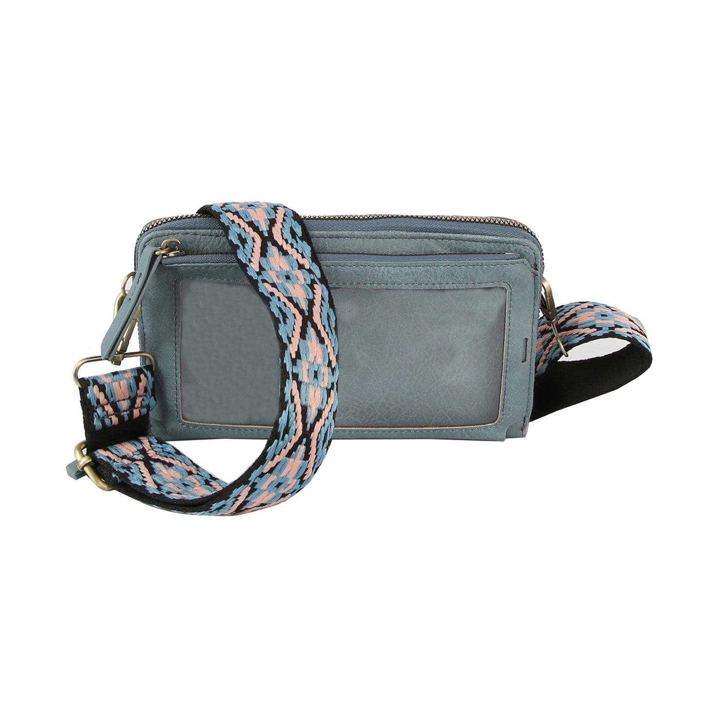 The Petite Multi Compartment Guitar Strap Crossbody is a small light blue faux leather bag with a clear front pocket and a wide detachable strap in a pink, blue, and black geometric pattern.