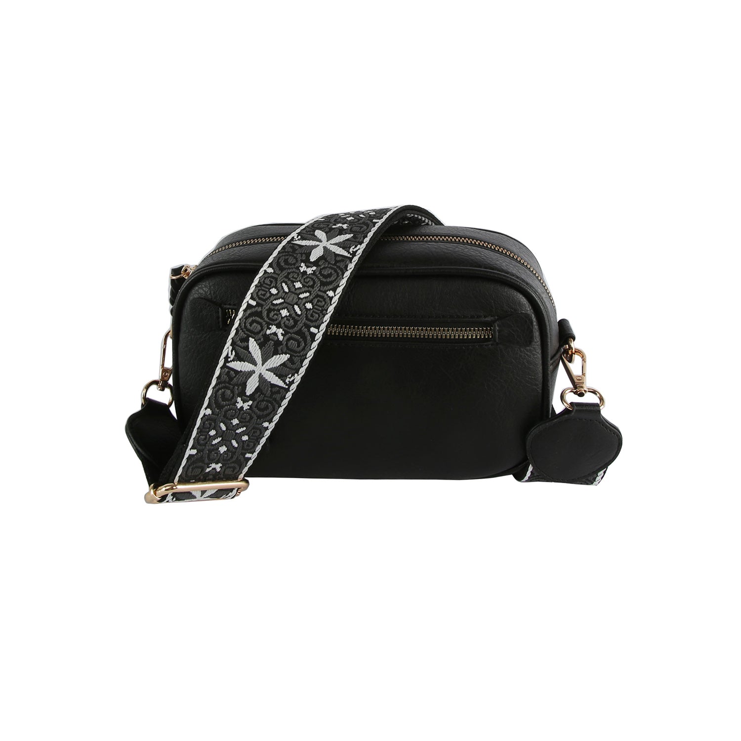 The Guitar Strap Crossbody Sling is a black faux leather bag with gold-toned hardware, a front zip pocket, and a wide, adjustable strap with a white floral and leaf pattern on black.
