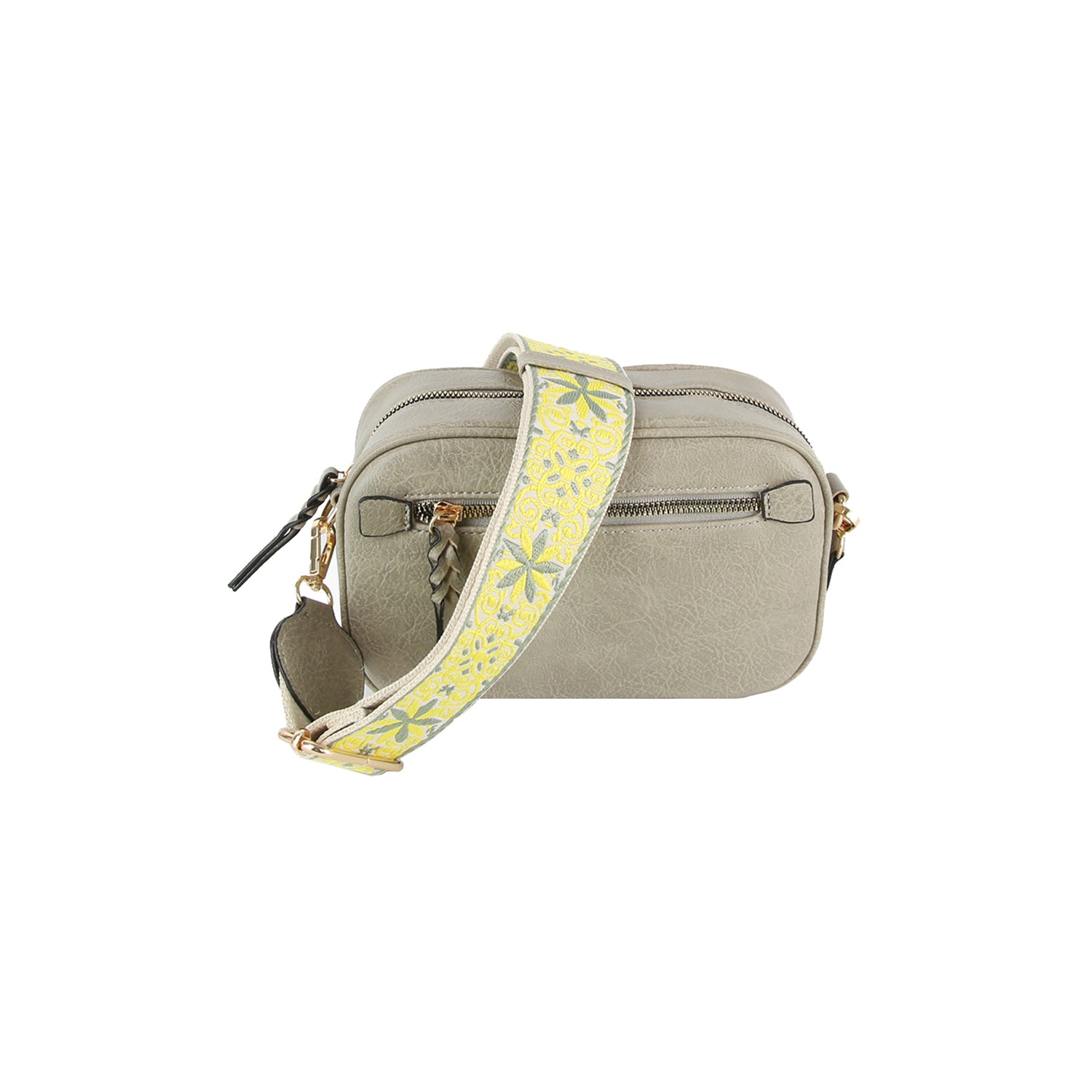 The Guitar Strap Crossbody Sling is a small, light gray faux leather bag with gold-toned hardware, two zippered compartments, and a wide adjustable yellow floral-patterned strap.