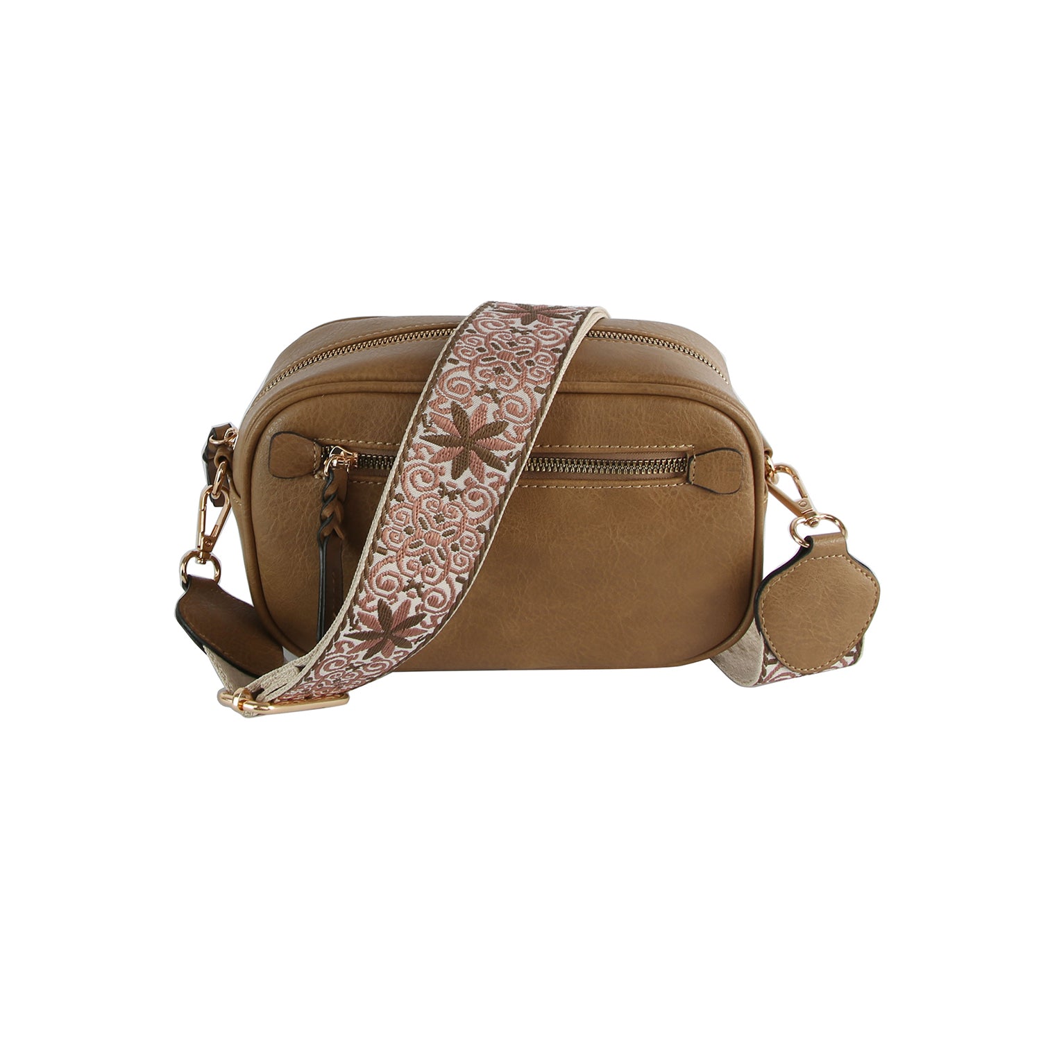 The Guitar Strap Crossbody Sling is a tan faux leather bag with an adjustable strap featuring a white floral pattern, gold-tone hardware, a front zipper pocket, and an attached small round pouch.