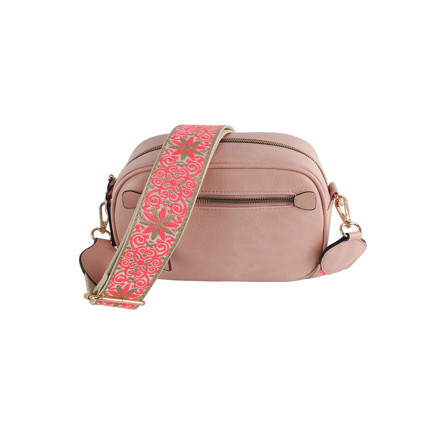 The Guitar Strap Crossbody Sling is a blush pink faux leather bag with two zippered compartments, gold-tone hardware, and a wide detachable strap adorned with a pink and gold floral pattern.