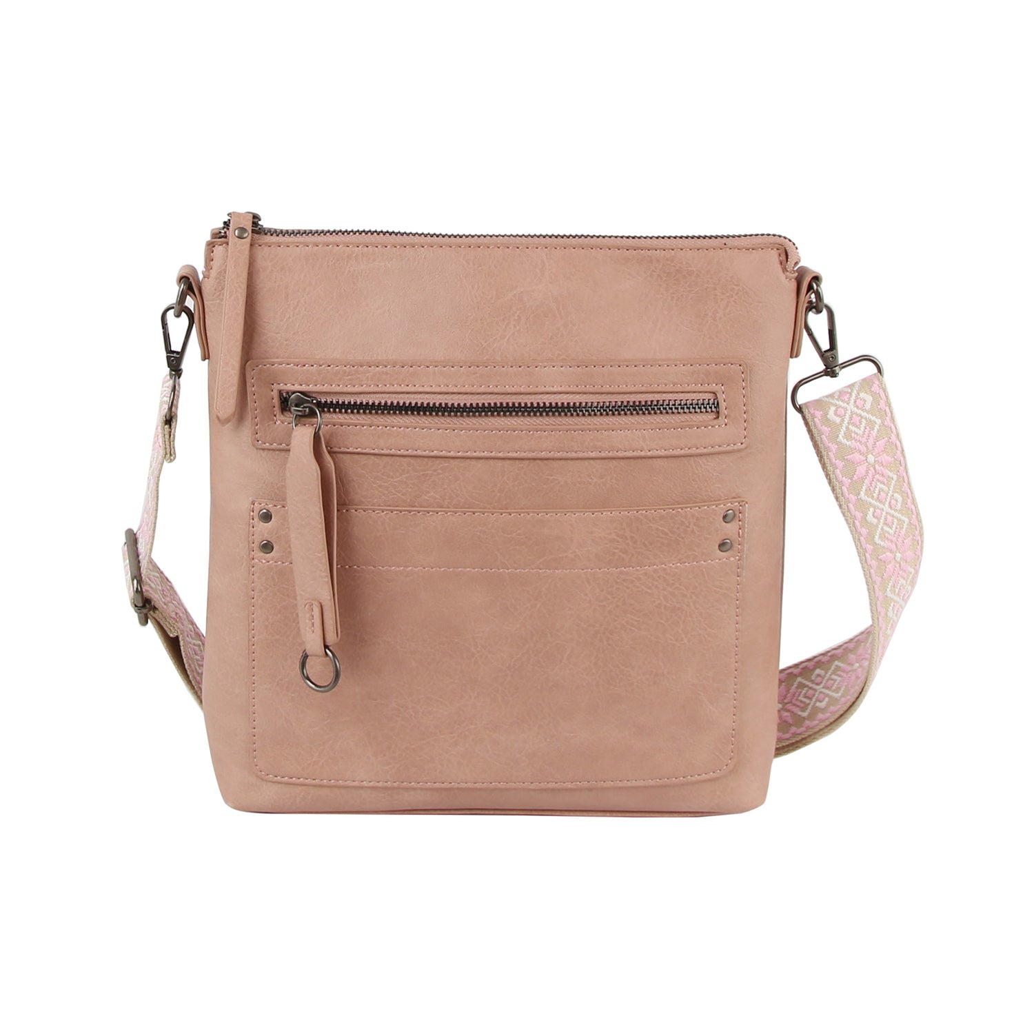 The Daily Zip Pocket Guitar Strap Crossbody Bag features blush pink faux leather with a textured finish, a front zipper pocket, two slip pockets, and a wide geometric light pink/white guitar strap with silver tone hardware.