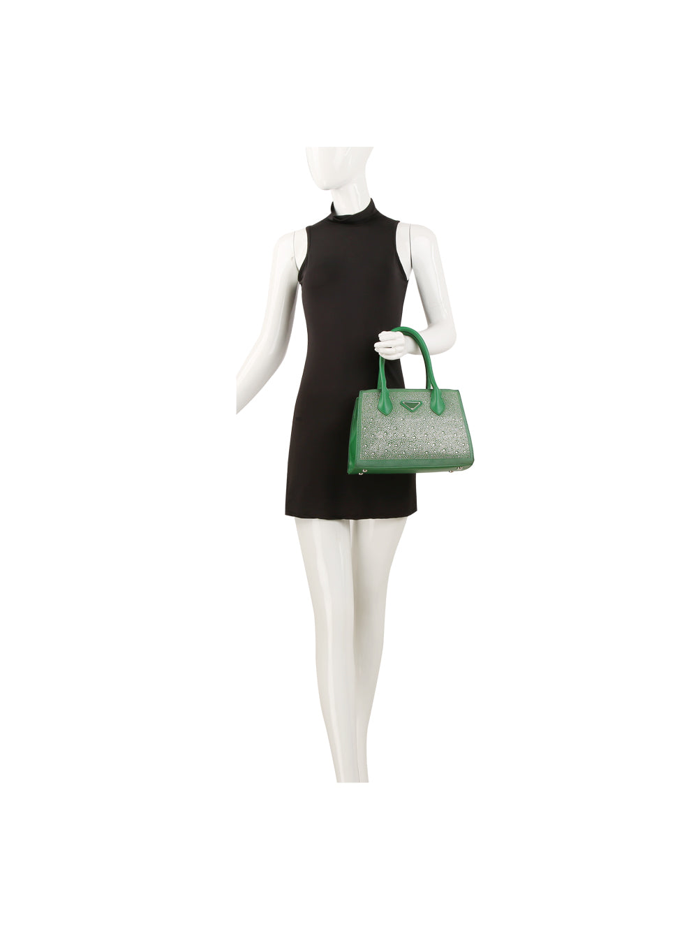 A mannequin in a sleeveless black mini dress holds the Dazzling Rhinestone Accented Hand Tote, a green faux leather handbag with a subtle pattern, in its left hand against a plain white background.