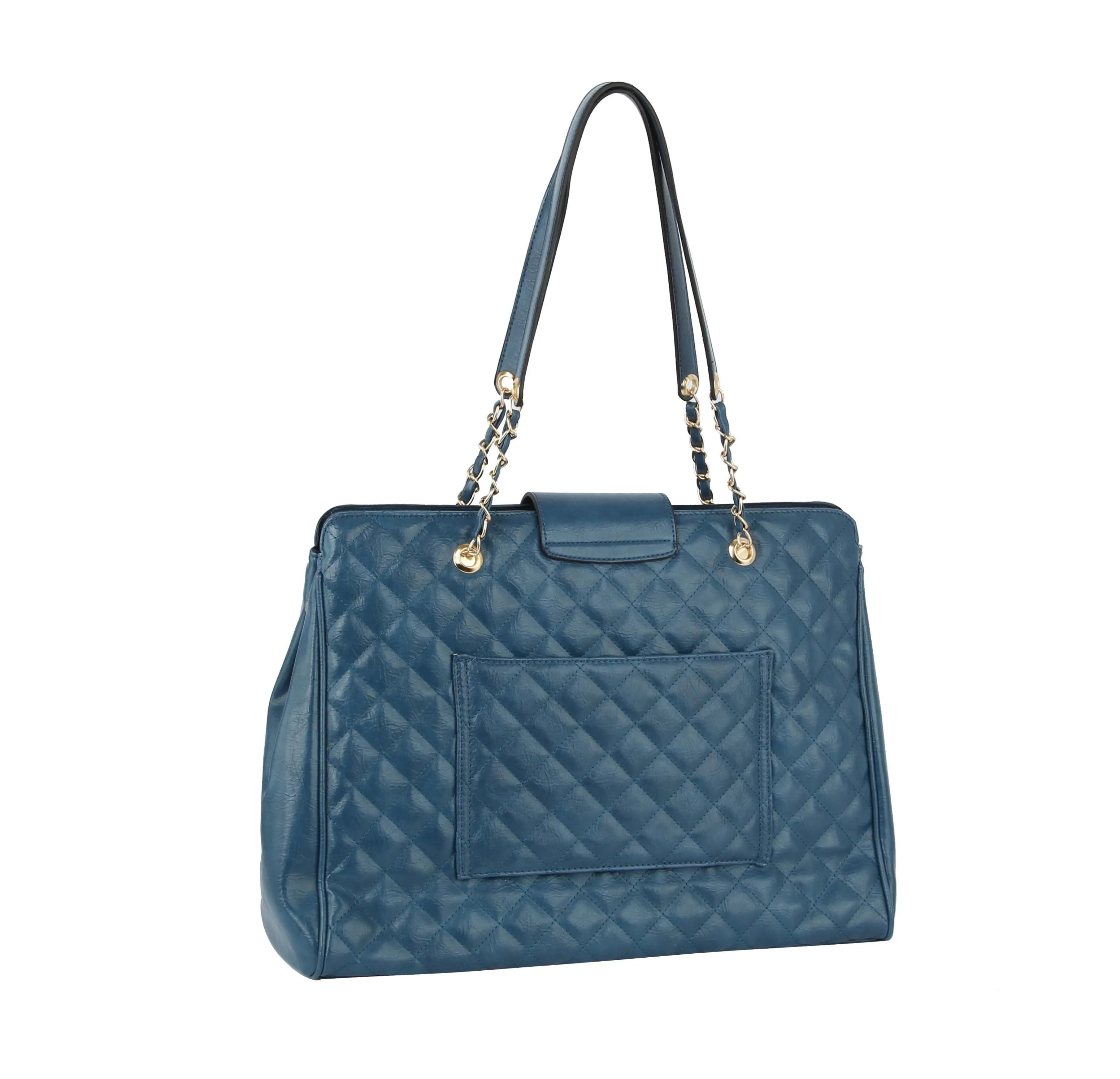 The Oversized Quilted Tote Travel Bag is blue with a rectangular front pocket, gold hardware, and dual faux leather handles with chain accents, shown on a white background.