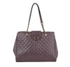 The Oversized Quilted Tote Travel Bag features purple faux leather, gold chain and leather straps, a top flap with gold turn-lock closure, and a structured silhouette—ideal for chic travel.