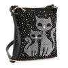 The Kitty Cat Sparkling Crossbody Sling is a chic black faux leather bag with two rhinestone cat designs, sparkling dot accents, an adjustable black strap, and gold-tone hardware.